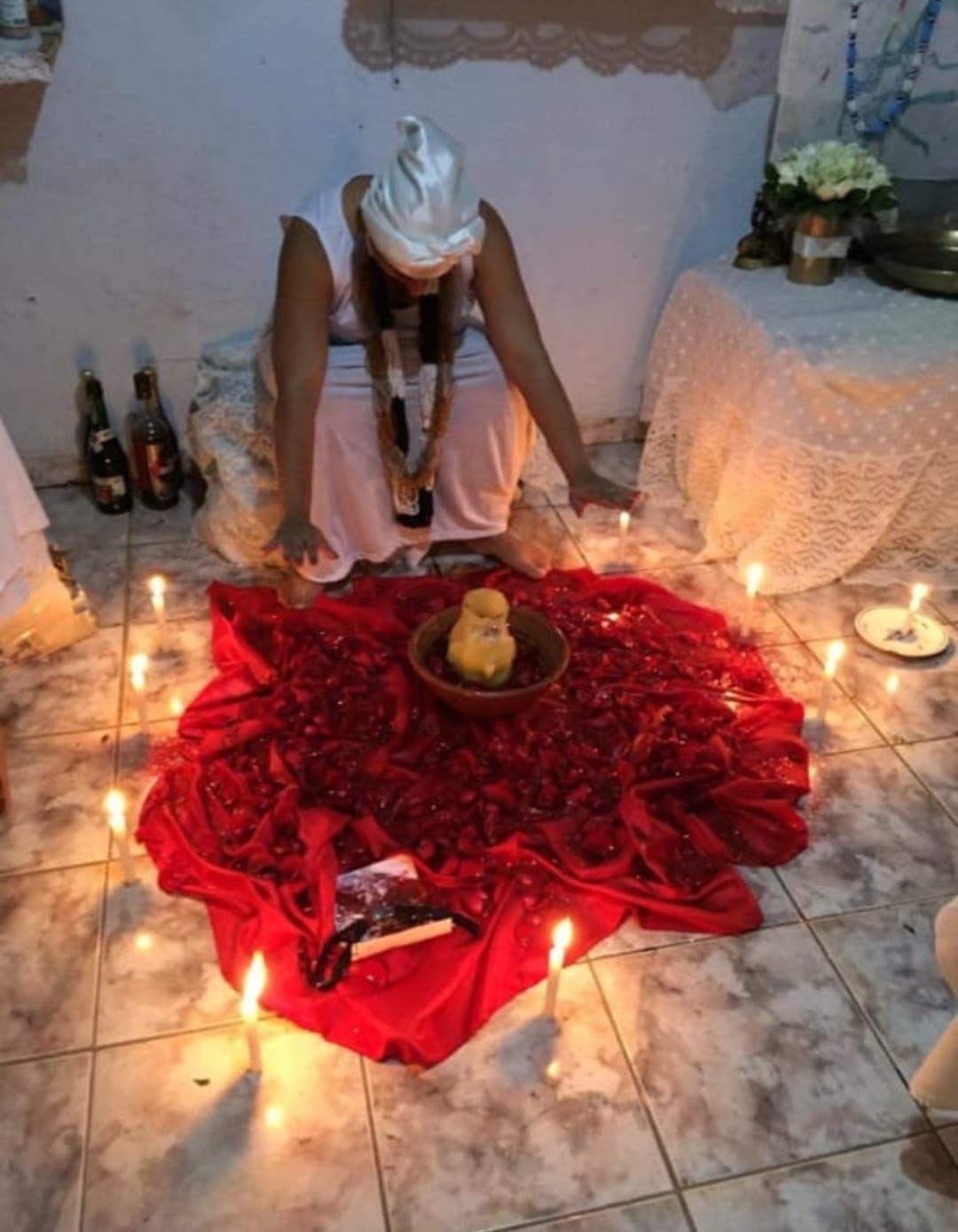 Mãe Iná realizando ritual espiritual em círculo de velas.